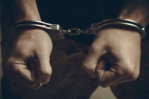 A man's hands in handcuffs.