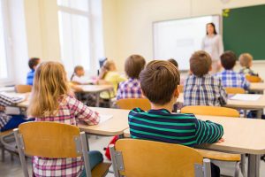 Expat students sitting in a classroom after moving to Brazil from Australia, listening to their teacher 