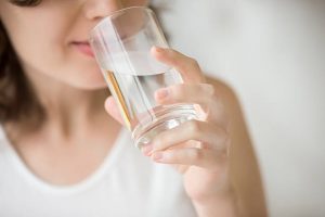 Woman drinking water from a glass after moving to Brazil from Australia